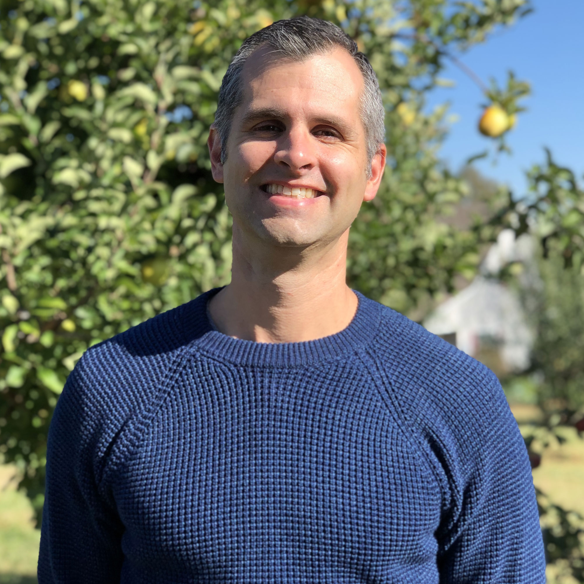 Headshot of me in an apple orchard.